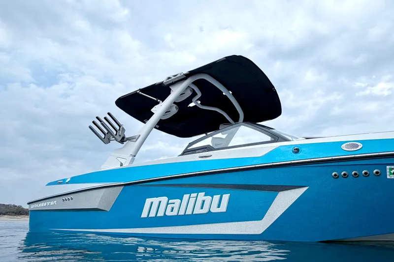 Slide: The Image of 2023 Malibu Wakesetter 23 MXZ boat on water, showcasing sleek design and vibrant blue color. - 9