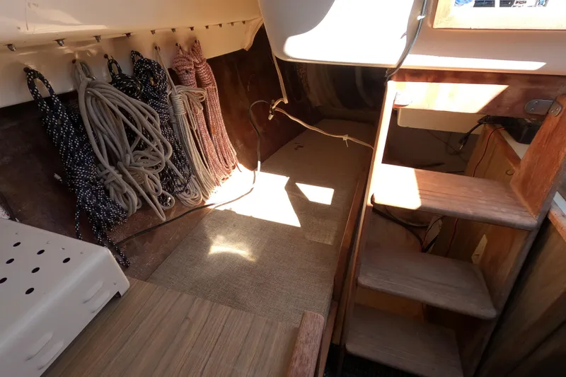 Slide: The Image of Interior of a 1972 Morgan 27 sailboat showing ropes and wooden steps. - 10