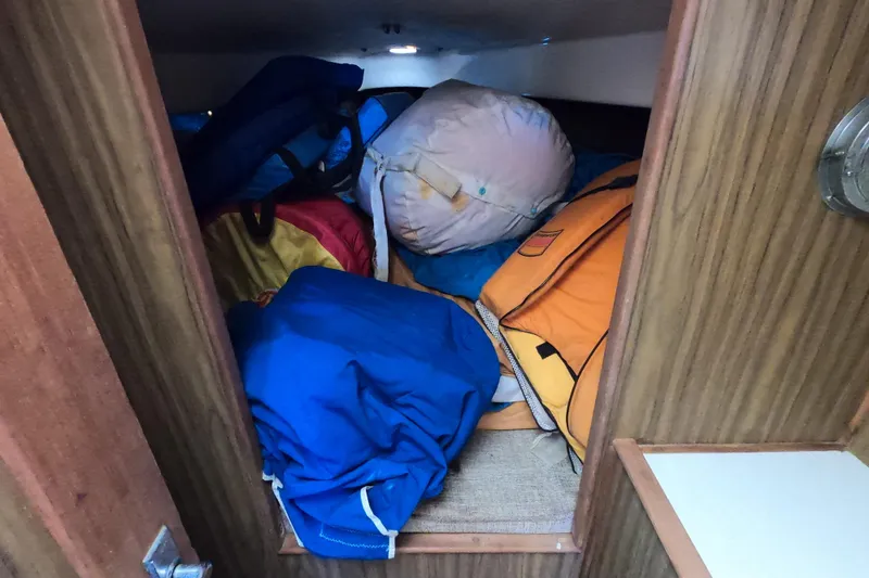 Slide: The Image of Storage area in a 1972 Morgan 27 sailboat filled with colorful bags and gear. - 16
