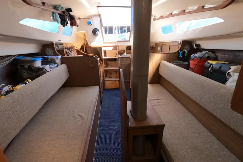 Slide: The Image of Interior of a 1972 Morgan 27 sailboat with cozy seating and storage. - 17