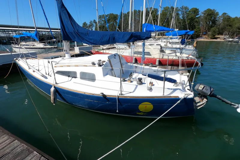 Slide: The Image of 1972 Morgan 27 sailboat docked at marina with blue hull and white deck. - 2