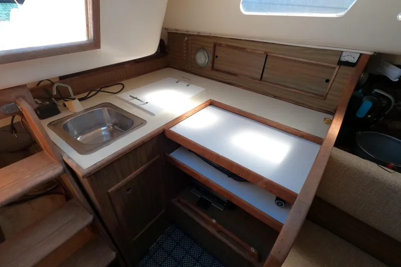 Slide: The Image of 1972 Morgan 27 yacht interior with compact kitchen, sink, and wooden cabinetry. - 9
