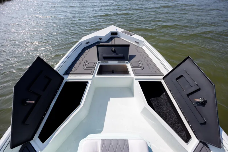 Slide: The Image of 2026 Excel 203 Bay Pro Elite boat with open storage compartments on the water. - 10
