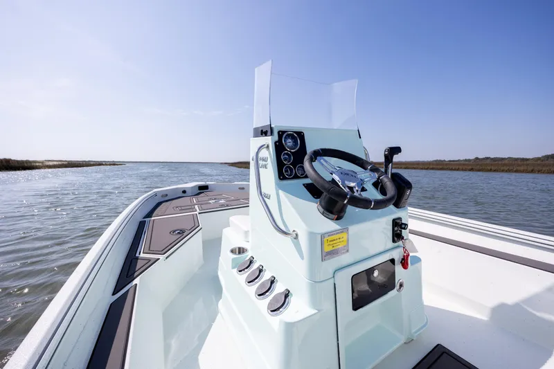 Slide: The Image of 2026 Excel 203 Bay Pro Elite boat on calm water, showcasing steering console and dashboard. - 19
