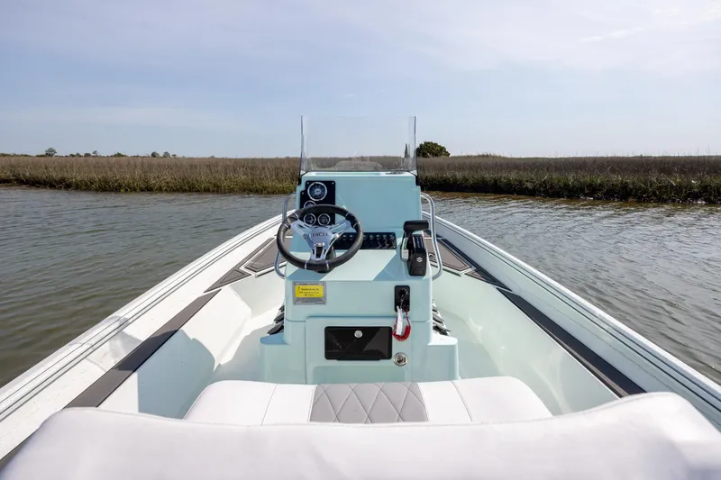 Slide: The Image of 2026 Excel 203 Bay Pro Elite boat on calm water, showcasing steering console and seating. - 22