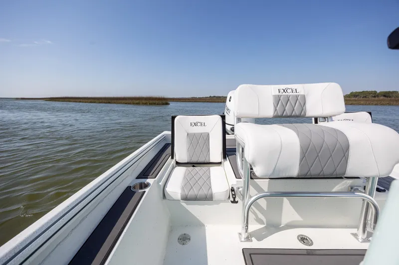 Slide: The Image of 2026 Excel 203 Bay Pro Elite boat interior with white seating on calm water. - 24