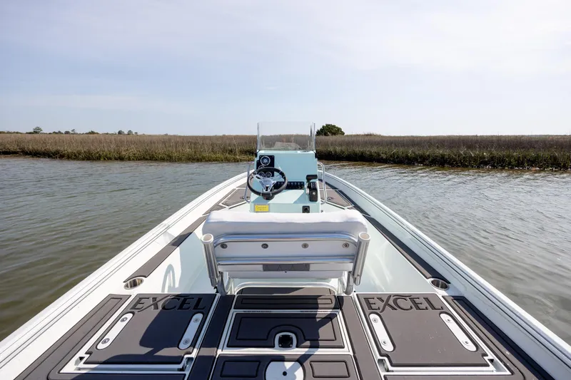 Slide: The Image of 2026 Excel 203 Bay Pro Elite boat on calm water, showcasing sleek design and spacious deck. - 28
