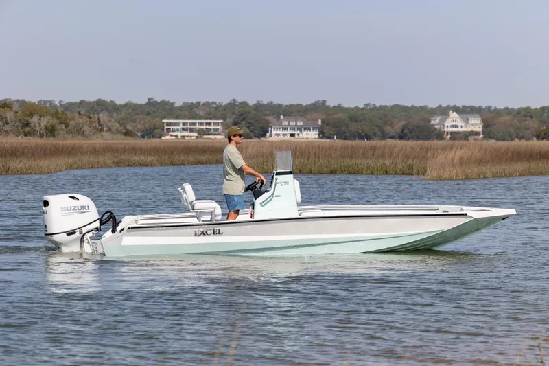 Slide: The Image of 2026 Excel 203 Bay Pro Elite boat cruising on a calm waterway with scenic background. - 4