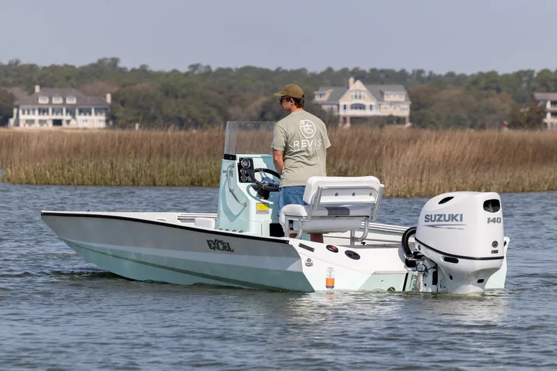 Slide: The Image of Man operating 2026 Excel 203 Bay Pro Elite boat with Suzuki engine on calm water. - 7