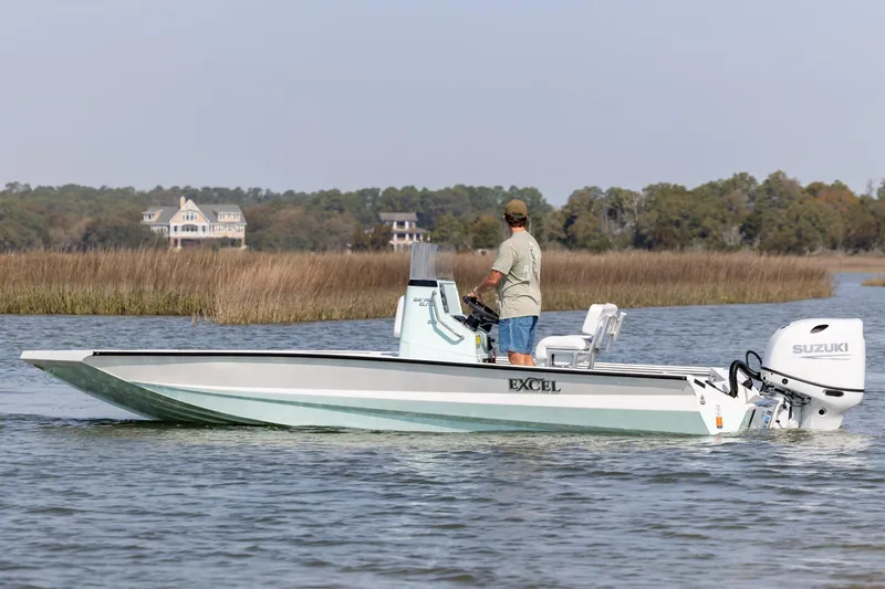 Slide: The Image of 2026 Excel 203 Bay Pro Elite boat cruising on a calm lake with scenic background. - 8