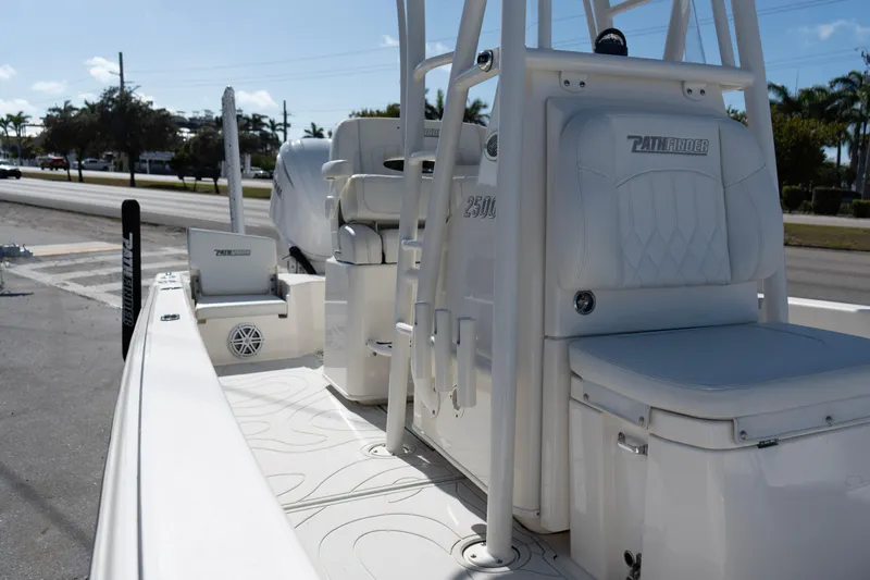 Slide: The Image of 2023 Pathfinder 2500 Hybrid boat interior with seating and console, parked near a road. - 10