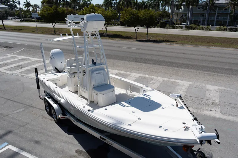 Slide: The Image of 2023 Pathfinder 2500 Hybrid boat on trailer, parked near a road with palm trees. - 3
