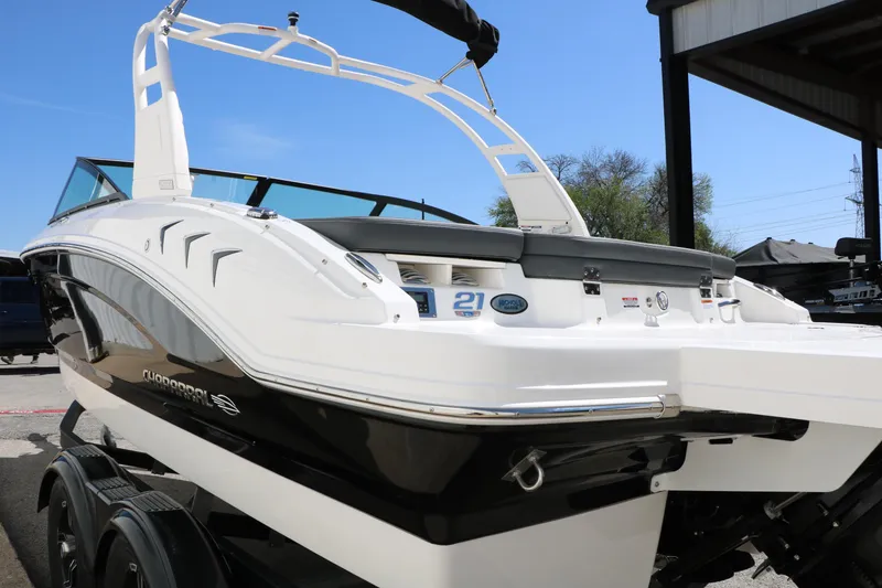 Slide: The Image of 2026 Chaparral 21 SSi boat with sleek design, parked outdoors under clear blue sky. - 9