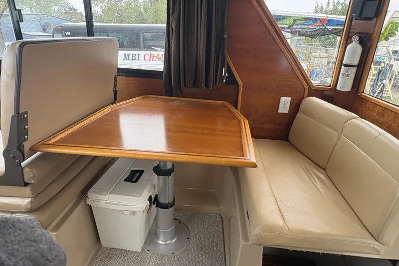 Slide: The Image of Interior of 2012 Cutwater C-26 boat with wooden table and beige seating. - 12