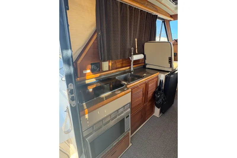 Slide: The Image of Interior of 2012 Cutwater C-26 boat featuring a compact kitchen area. - 13