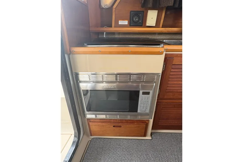 Slide: The Image of 2012 Cutwater C-26 interior with built-in microwave and wooden cabinetry. - 14