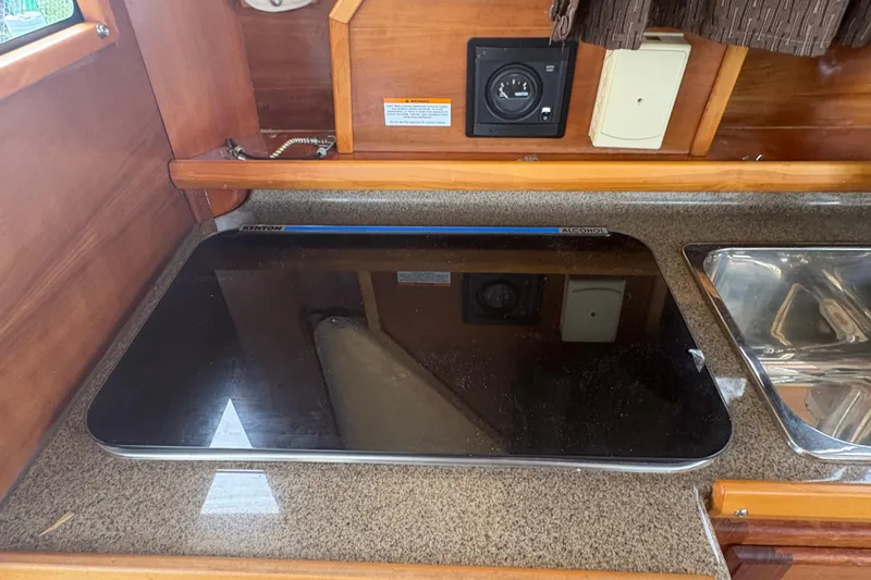Slide: The Image of Interior of 2012 Cutwater C-26 boat featuring a Kenyon stove and sink. - 15