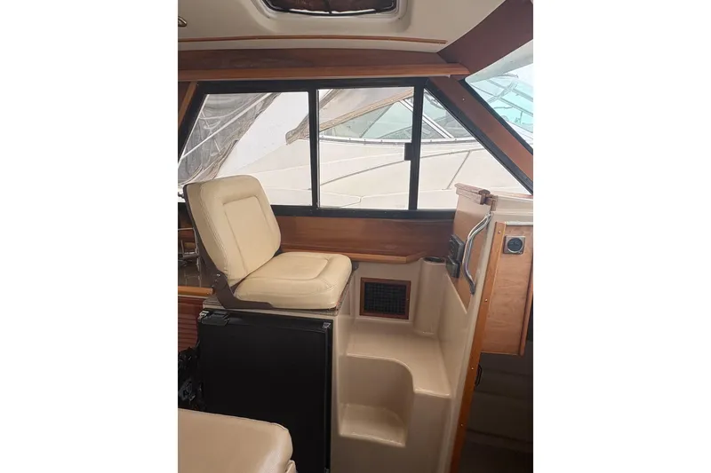 Slide: The Image of Interior of a 2012 Cutwater C-26 boat featuring a beige captain's seat and wooden accents. - 16