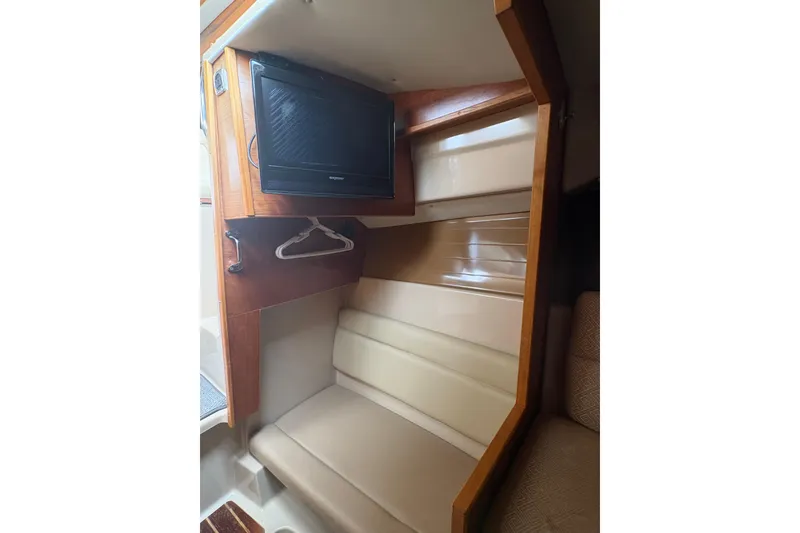 Slide: The Image of 2012 Cutwater C-26 interior with TV, beige seating, and wooden accents. - 22