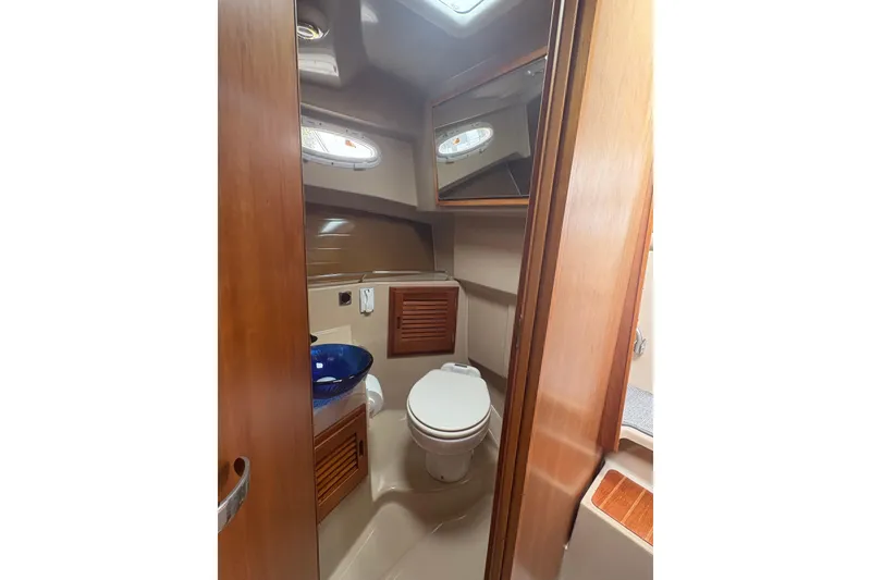 Slide: The Image of 2012 Cutwater C-26 boat bathroom with wooden cabinetry and blue sink. - 23