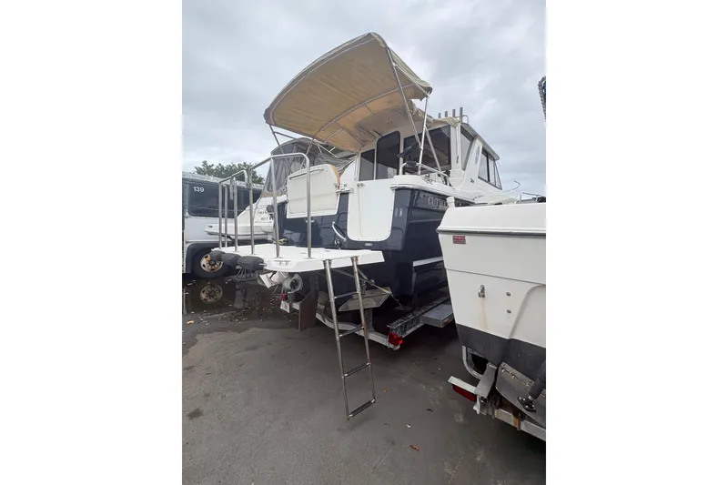 Slide: The Image of 2012 Cutwater C-26 boat with canopy and ladder, parked on a trailer. - 3