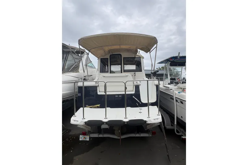 Slide: The Image of 2012 Cutwater C-26 boat with canopy, docked among other vessels. - 4