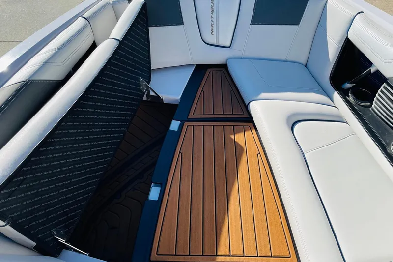 Slide: The Image of 2015 Nautique Super Air Nautique G23 interior with white seating and teak flooring. - 10