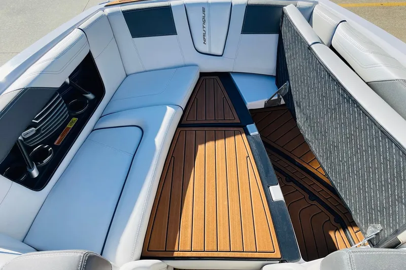 Slide: The Image of 2015 Nautique Super Air Nautique G23 interior with white seating and teak flooring. - 11