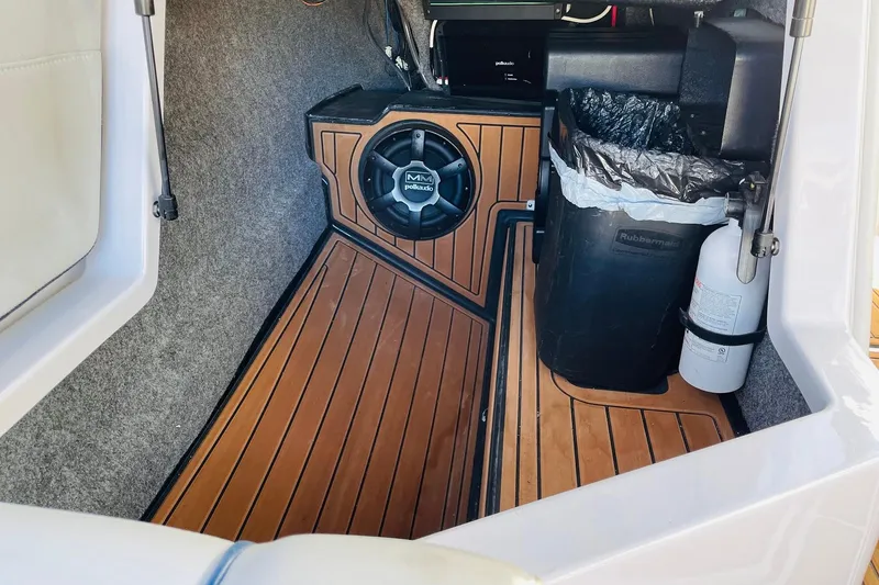 Slide: The Image of 2015 Nautique Super Air Nautique G23 interior with speaker, trash bin, and fire extinguisher. - 22
