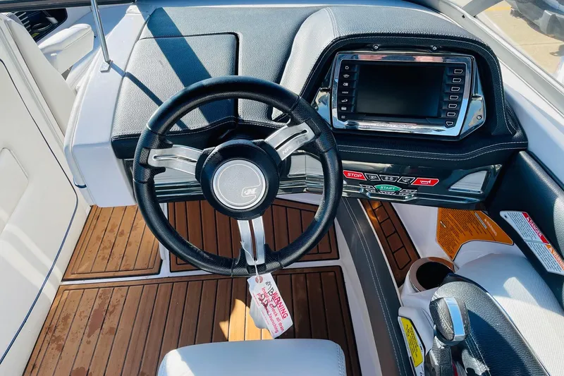 Slide: The Image of 2015 Nautique Super Air Nautique G23 dashboard with steering wheel and control panel. - 28