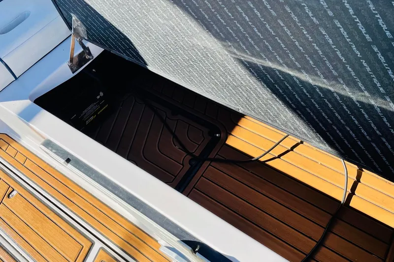 Slide: The Image of 2015 Nautique Super Air Nautique G23 storage compartment with teak flooring and open hatch. - 33