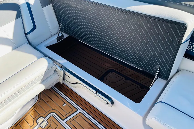 Slide: The Image of 2015 Nautique Super Air Nautique G23 boat storage compartment with open lid and cushioned seating. - 38