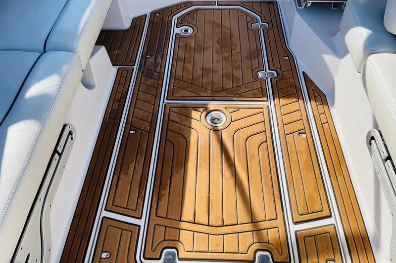 Slide: The Image of 2015 Nautique Super Air Nautique G23 boat interior with teak flooring and white seating. - 43