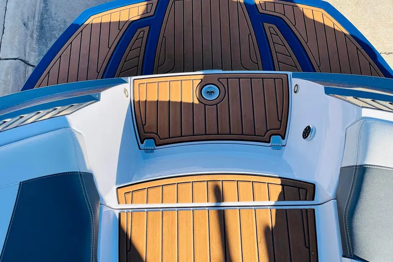 Slide: The Image of 2015 Nautique Super Air Nautique G23 boat deck with teak flooring and blue accents. - 51