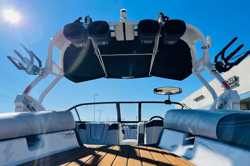 Slide: The Image of 2015 Nautique Super Air Nautique G23 interior with speakers and seating, under clear blue sky. - 53