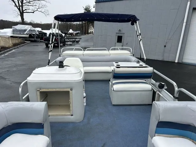 Slide: The Image of 1998 Palm Beach 200 pontoon boat with blue and white seating. - 10
