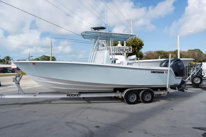 The Image of 2024 Contender 25 Tournament boat on trailer, parked outdoors under a blue sky. - 0