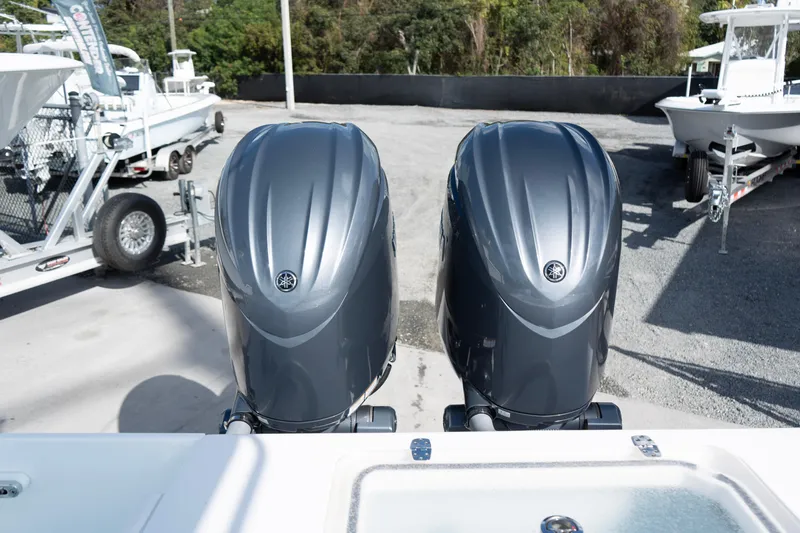 Slide: The Image of Twin outboard engines on a 2024 Contender 25 Tournament boat, parked on a trailer. - 13