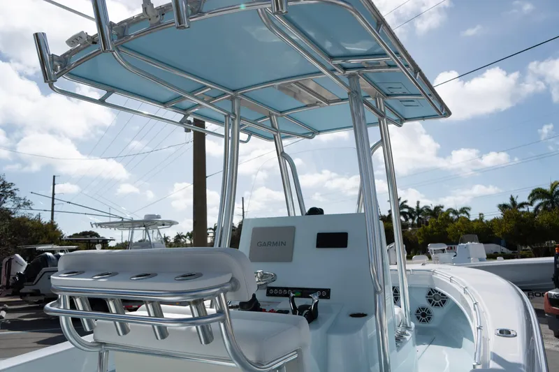 Slide: The Image of 2024 Contender 25 Tournament boat with T-top and Garmin electronics, docked under a sunny sky. - 9