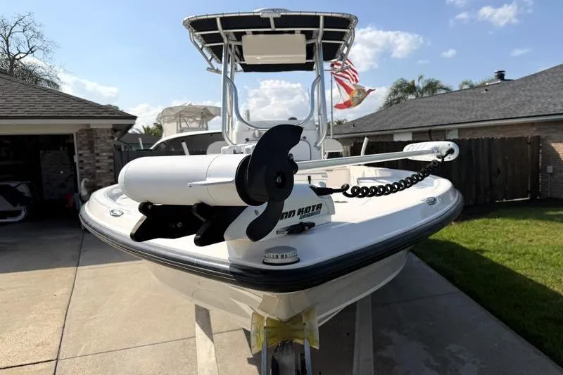 Slide: The Image of 2012 Edgewater 240 Inshore boat with trolling motor, parked in driveway. - 12