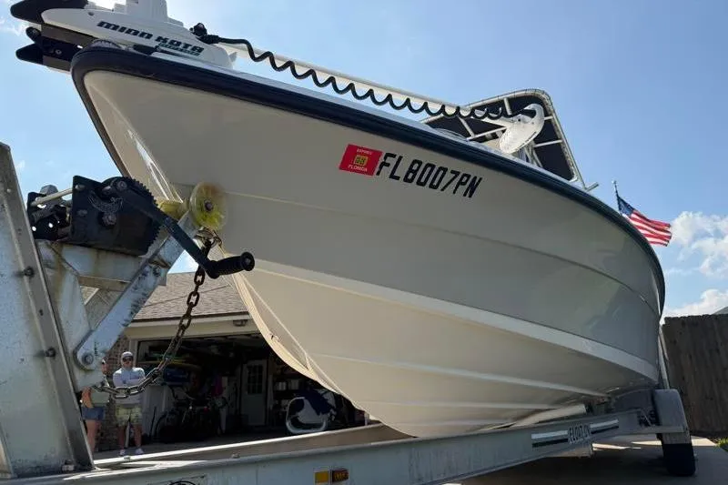 Slide: The Image of 2012 Edgewater 240 Inshore boat on trailer with Florida registration, American flag in background. - 15