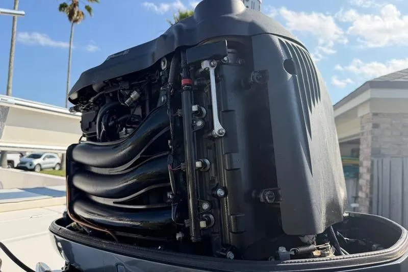 Slide: The Image of Close-up of a 2012 Edgewater 240 Inshore boat engine under a clear sky. - 24