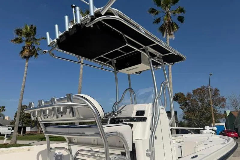 Slide: The Image of 2012 Edgewater 240 Inshore boat with T-top and rod holders, parked outdoors. - 27