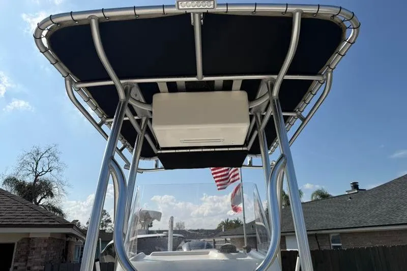 Slide: The Image of 2012 Edgewater 240 Inshore boat with T-top and American flag in sunny setting. - 40