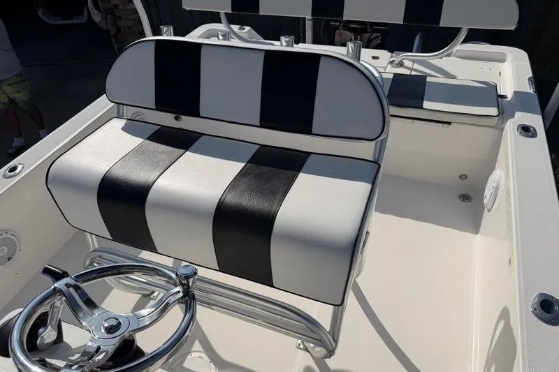 Slide: The Image of 2012 Edgewater 240 Inshore boat interior with striped seating and steering wheel. - 51
