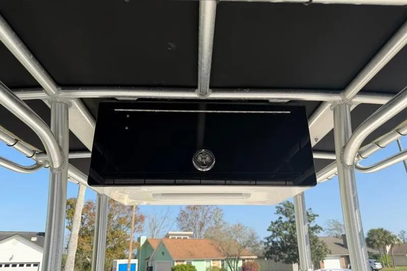 Slide: The Image of T-top storage compartment on a 2012 Edgewater 240 Inshore boat, with a black cover. - 53