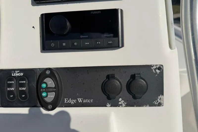 Slide: The Image of Control panel of a 2012 Edgewater 240 Inshore boat with audio system and switches. - 58
