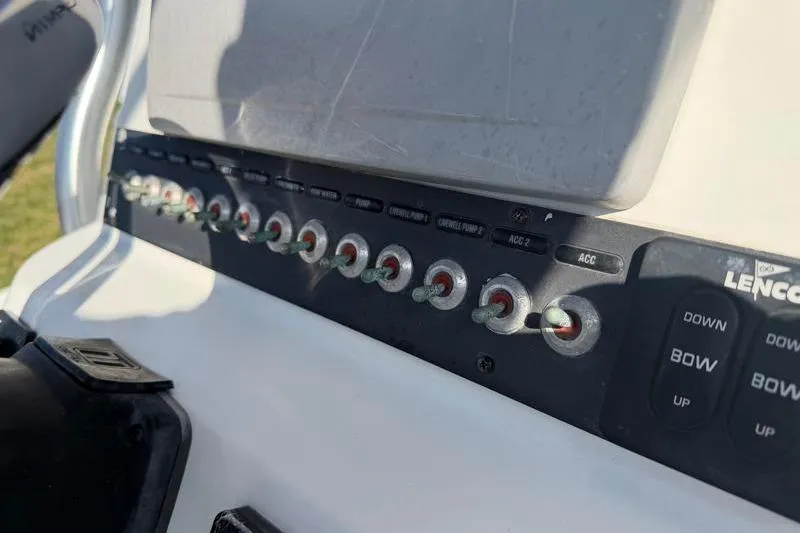 Slide: The Image of Control panel of a 2012 Edgewater 240 Inshore boat with switches and buttons. - 59