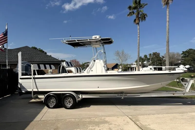 Slide: The Image of 2012 Edgewater 240 Inshore boat on trailer, parked in driveway under clear sky. - 6