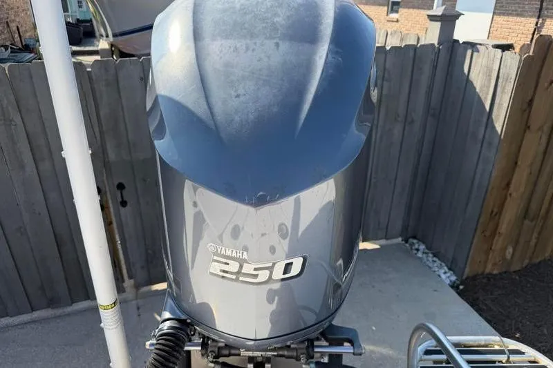 Slide: The Image of Yamaha 250 outboard motor on 2012 Edgewater 240 Inshore boat, docked near wooden fence. - 68